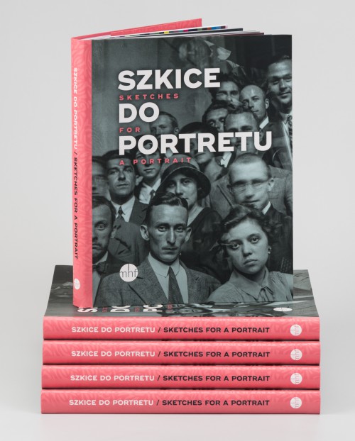 Książka stojąca na stosie innych książek, na okładce zdjęcie czarno-białe, z początku XX wieku, portret dużej grupy młodych ludzi patrzących w obiektyw