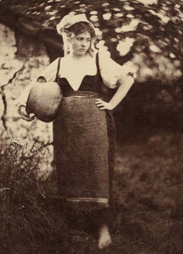 Młoda dziewczyna trzymająca na biodrze duży dzban. 