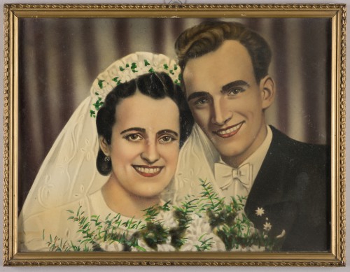 Portret pary młodej kolorowany, oprawiony w złocistą ramę.