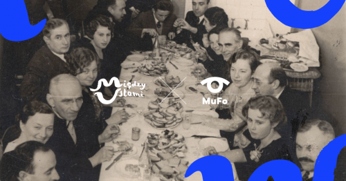 Grupa ludzi siedząca przy bogato zastawionym stole. 