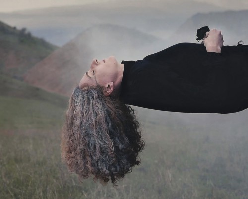 Kobieta unosząca się nad ziemią w pozycji horyzontalnej. 