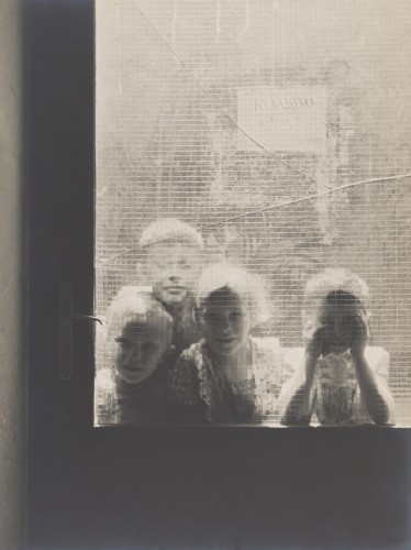 Dzieci zaglądające do pomieszczenia przez szybę. 