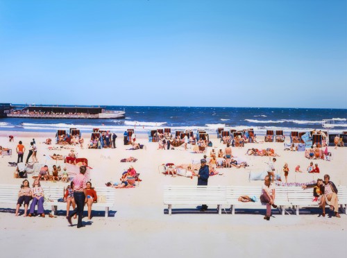 Plaża pełna odpoczywających ludzi. 